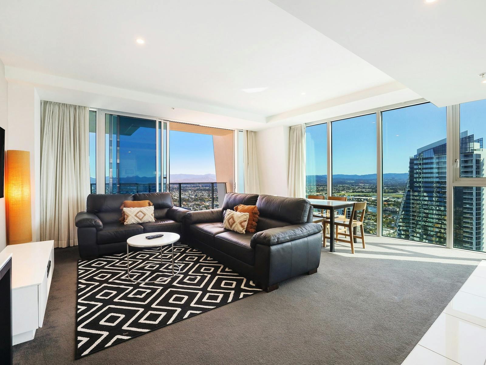 Lounge room with TV and city views - Hilton Residences Gold Coast Holidays Lounge room with TV and city views - Hilton Residences Gold Coast Holidays