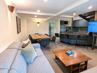 Living room space with couches, tea tables, television, table and chairs