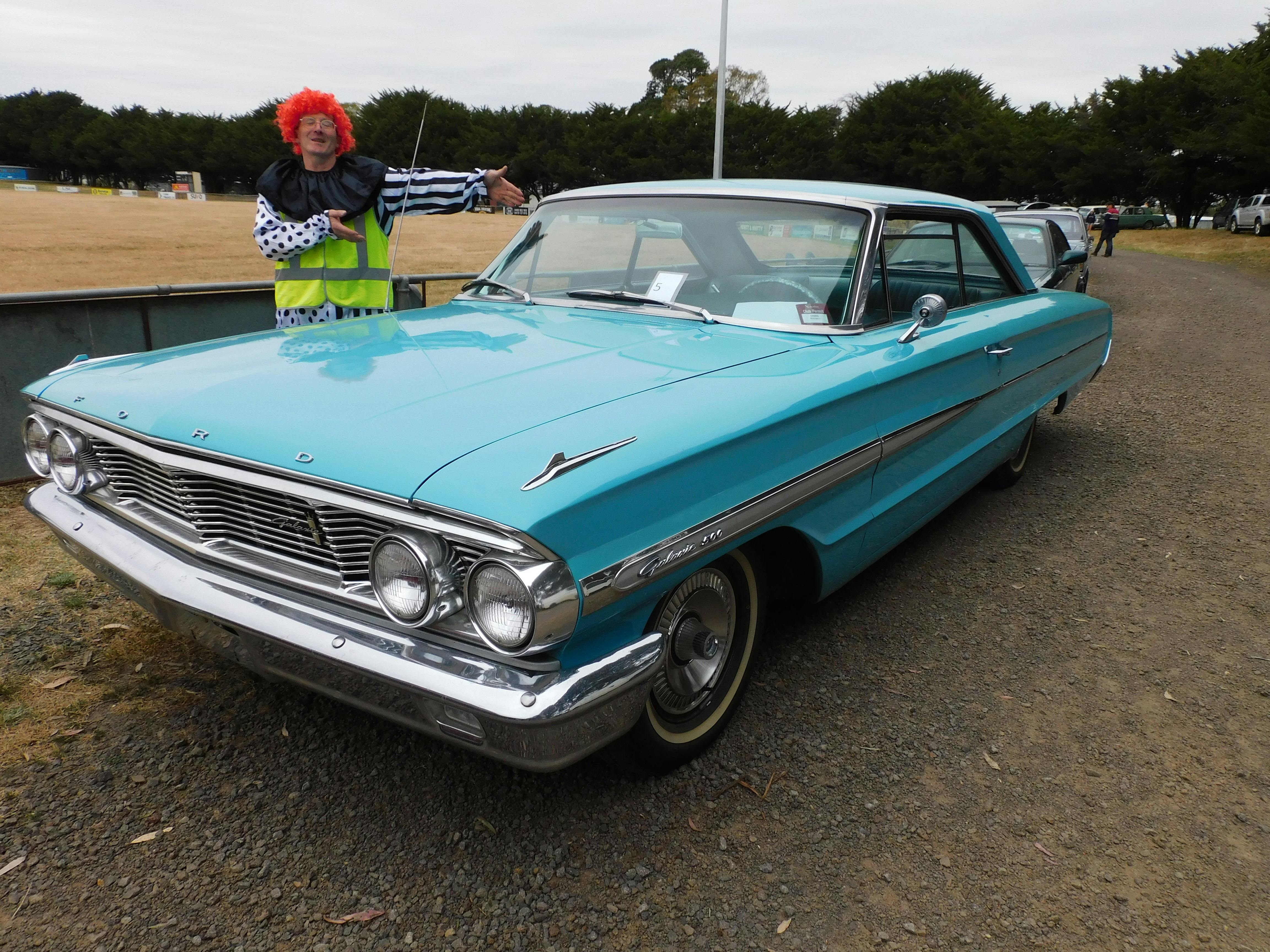 Clown beside a vintage car