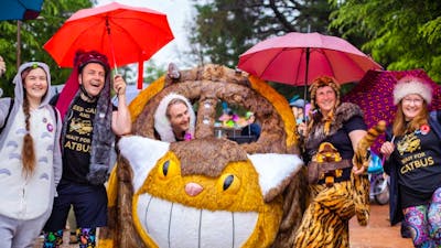 People smiling and posing with Cat Bus kinetic sculpture