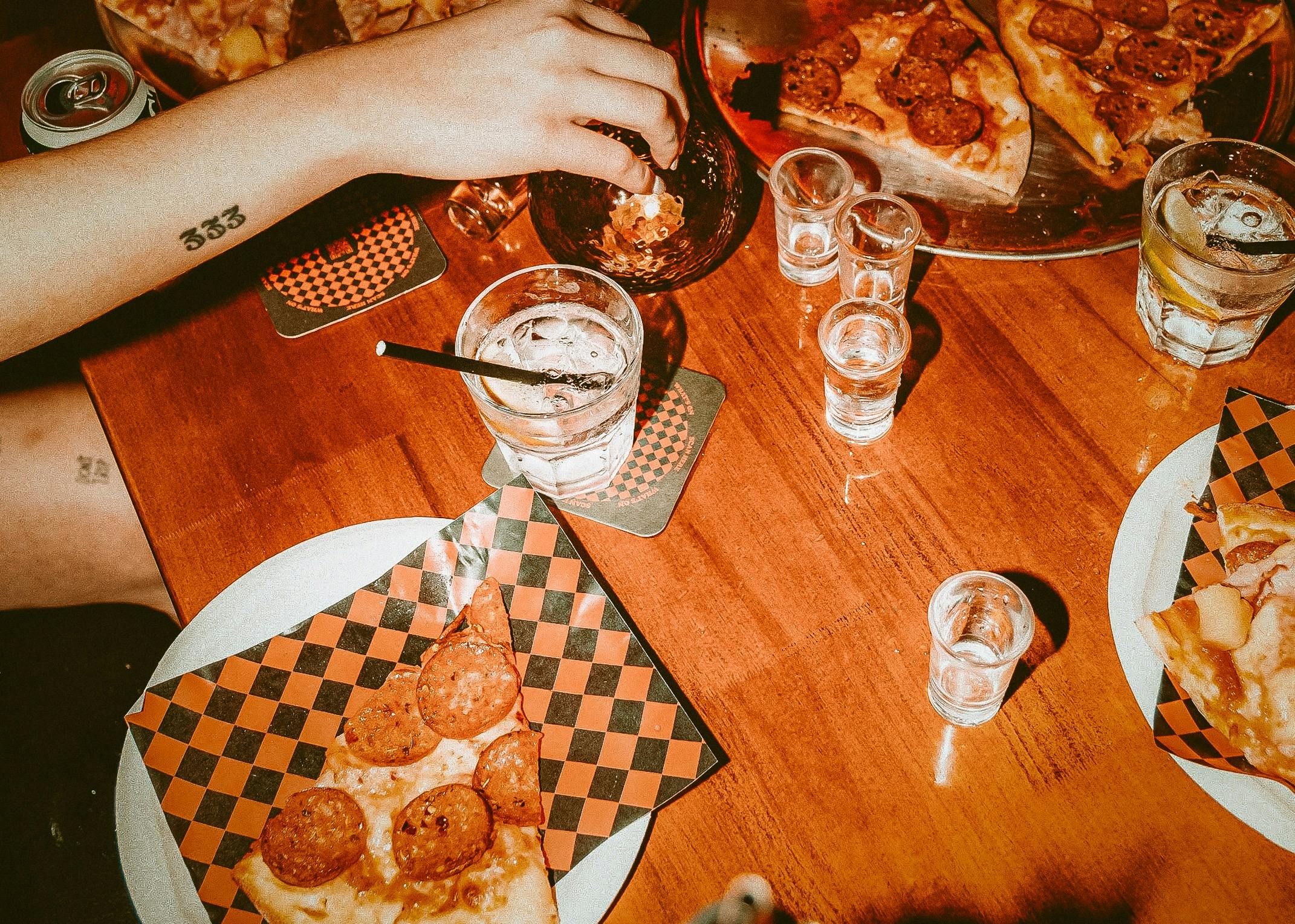 Photo of pizza by the slice and drinks on table