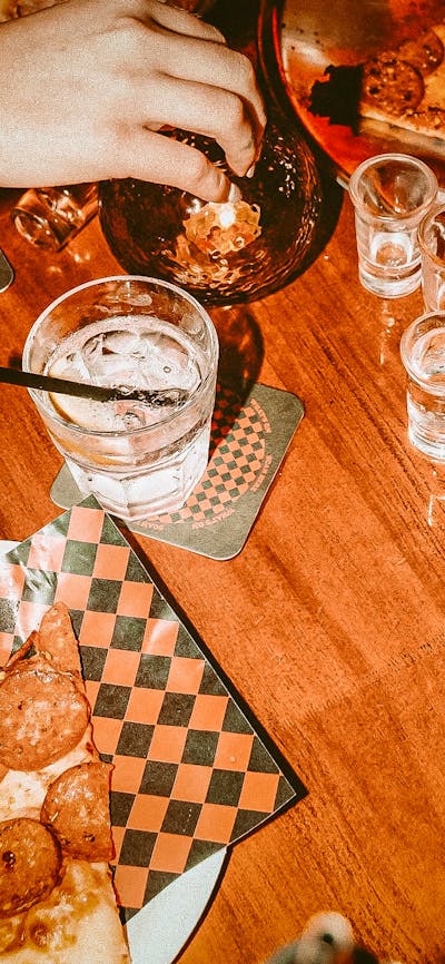 Photo of pizza by the slice and drinks on table