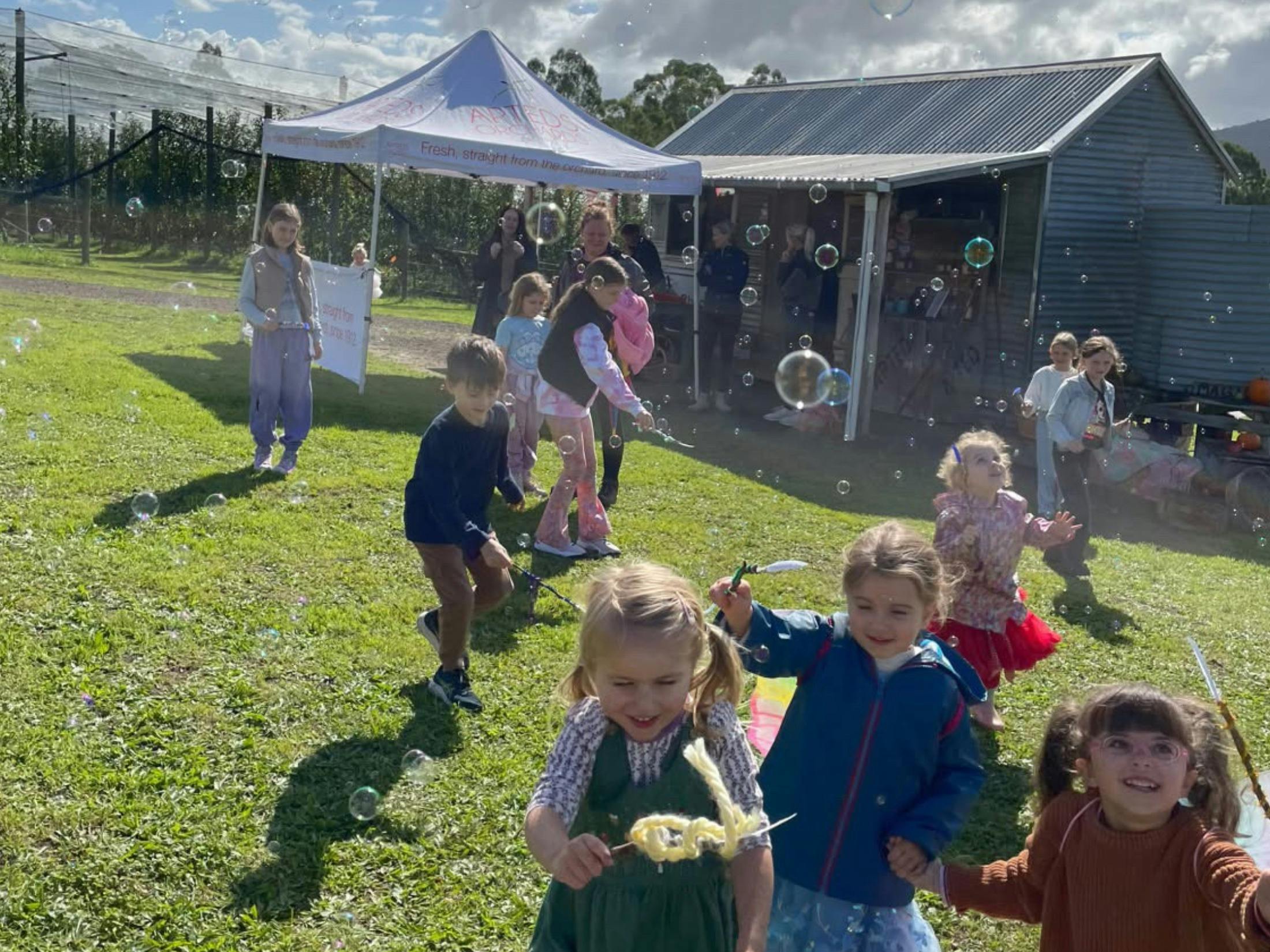 A photo of children running with bubbles in the air