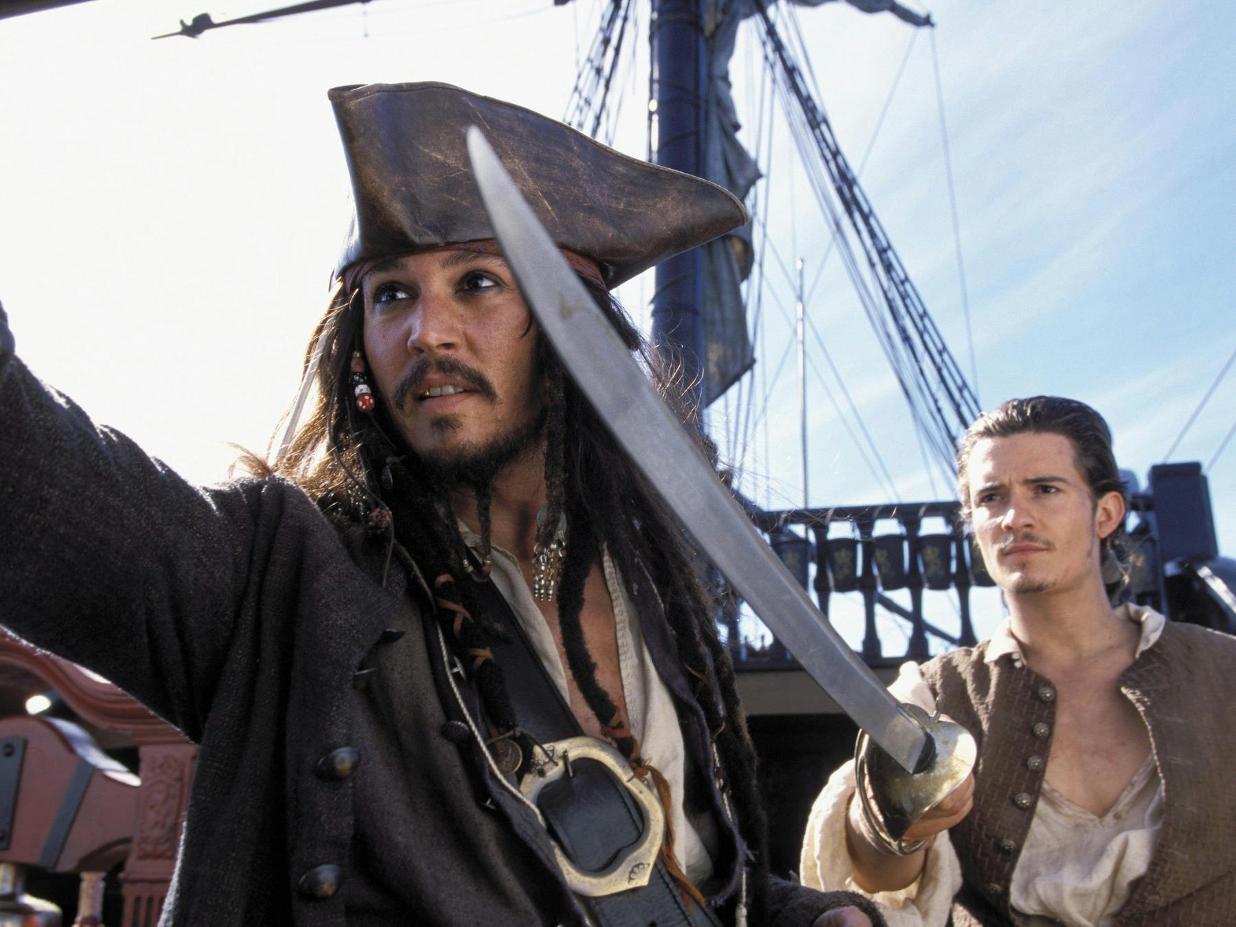 Pirate on a ship with another man pointing a sword to the left of the camera