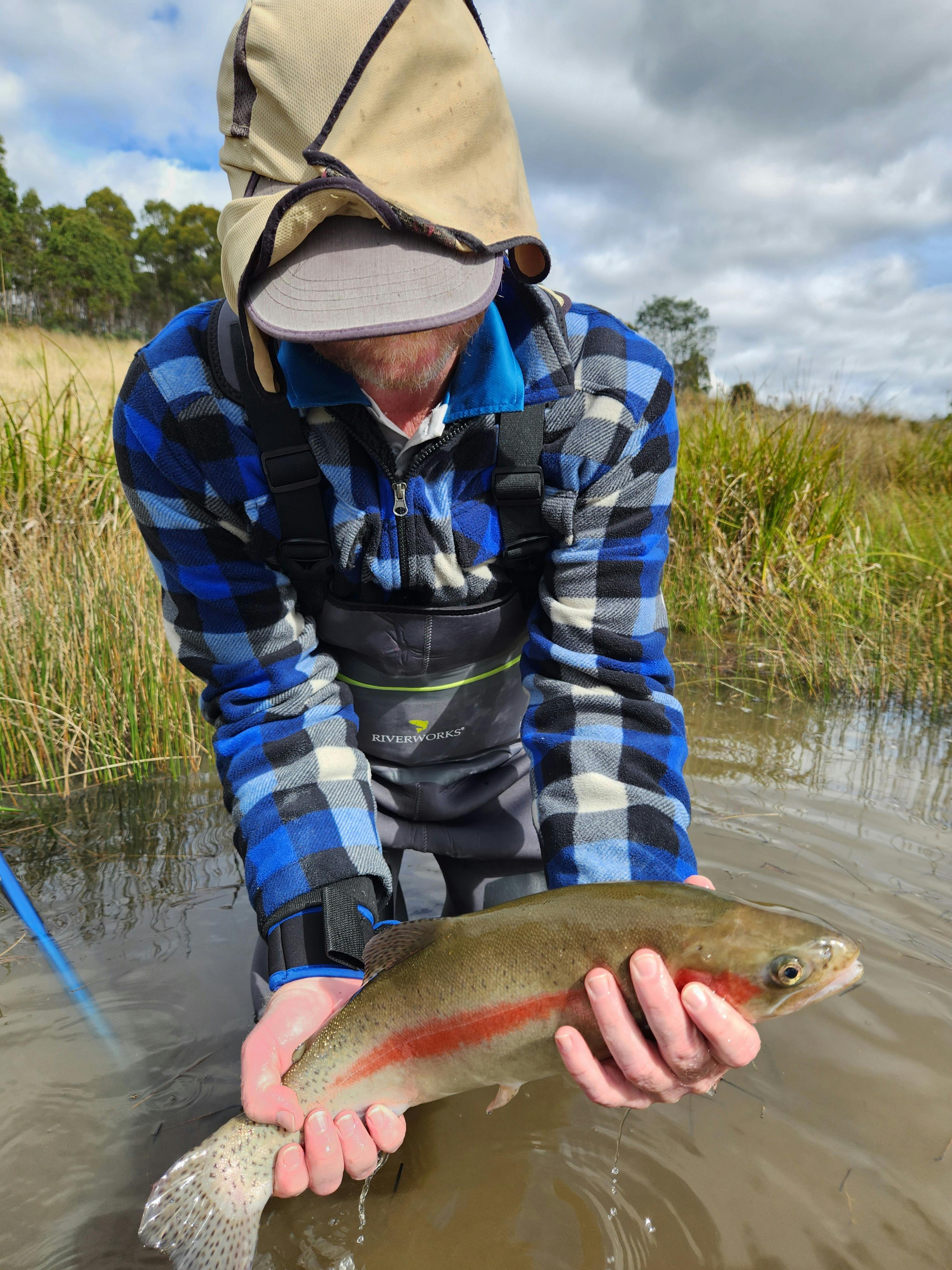 A fisherman holding a rainbow trout he has just caught at Twin Lakes before letting it go.