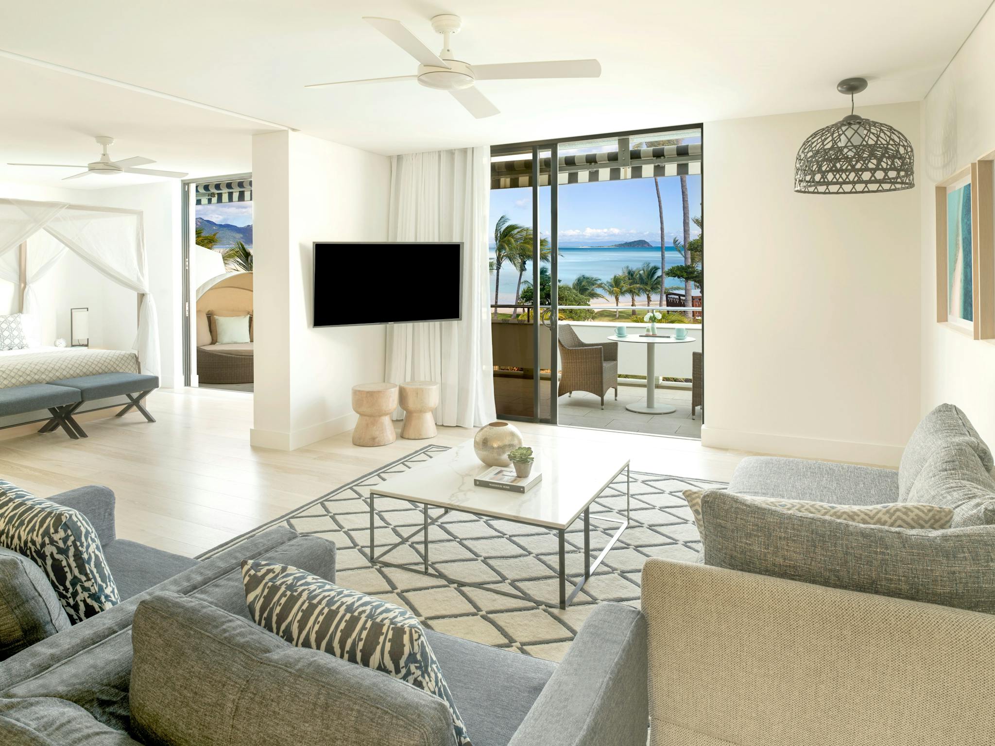 Open-plan suite featuring a canopy bed, seating area, dining table, and a spacious modern bathroom. Open-plan suite featuring a canopy bed, seating area, dining table, and a spacious modern bathroom.