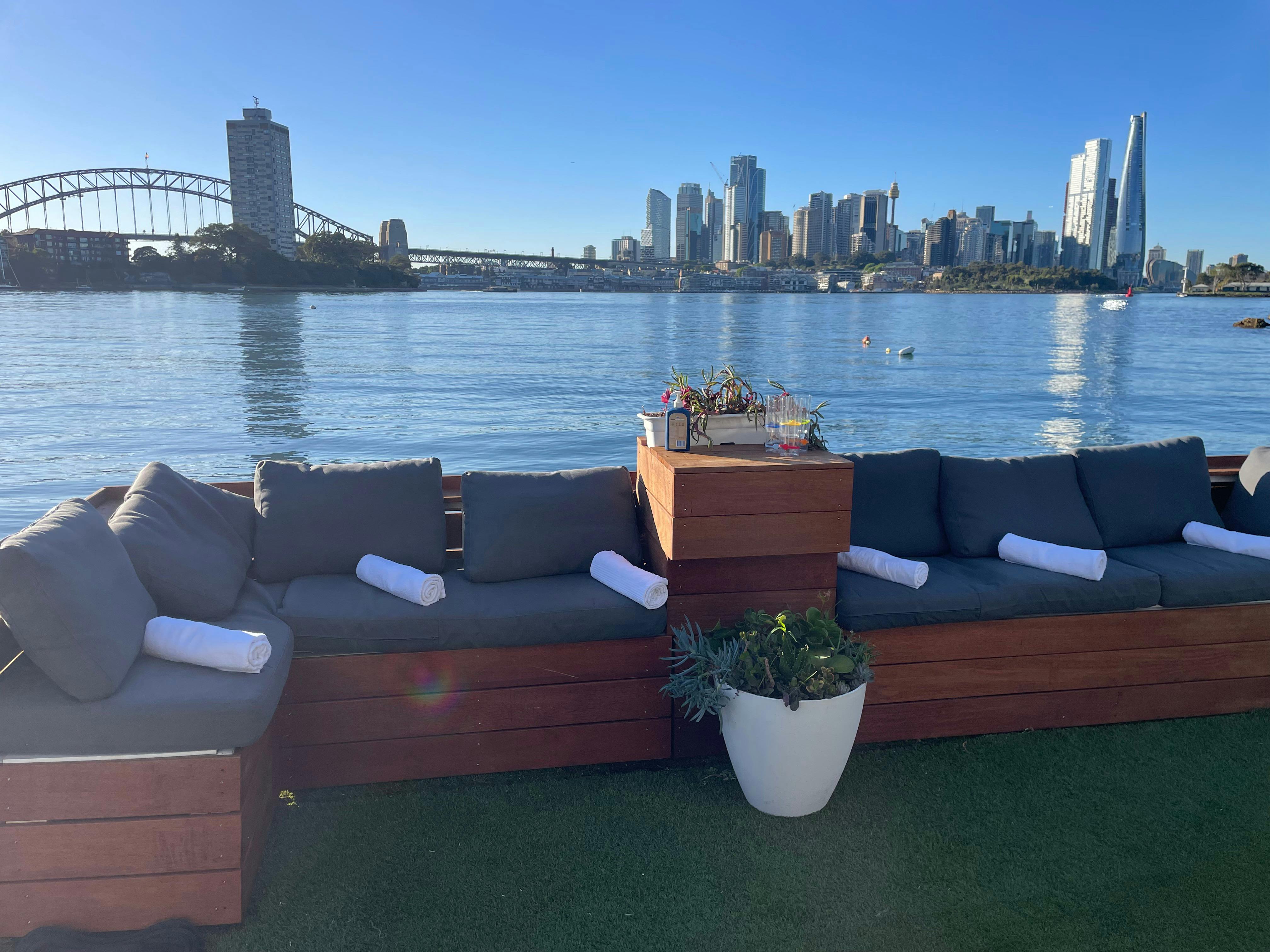 Lounge on deck with towels rolled up and Harbour Bridge in background