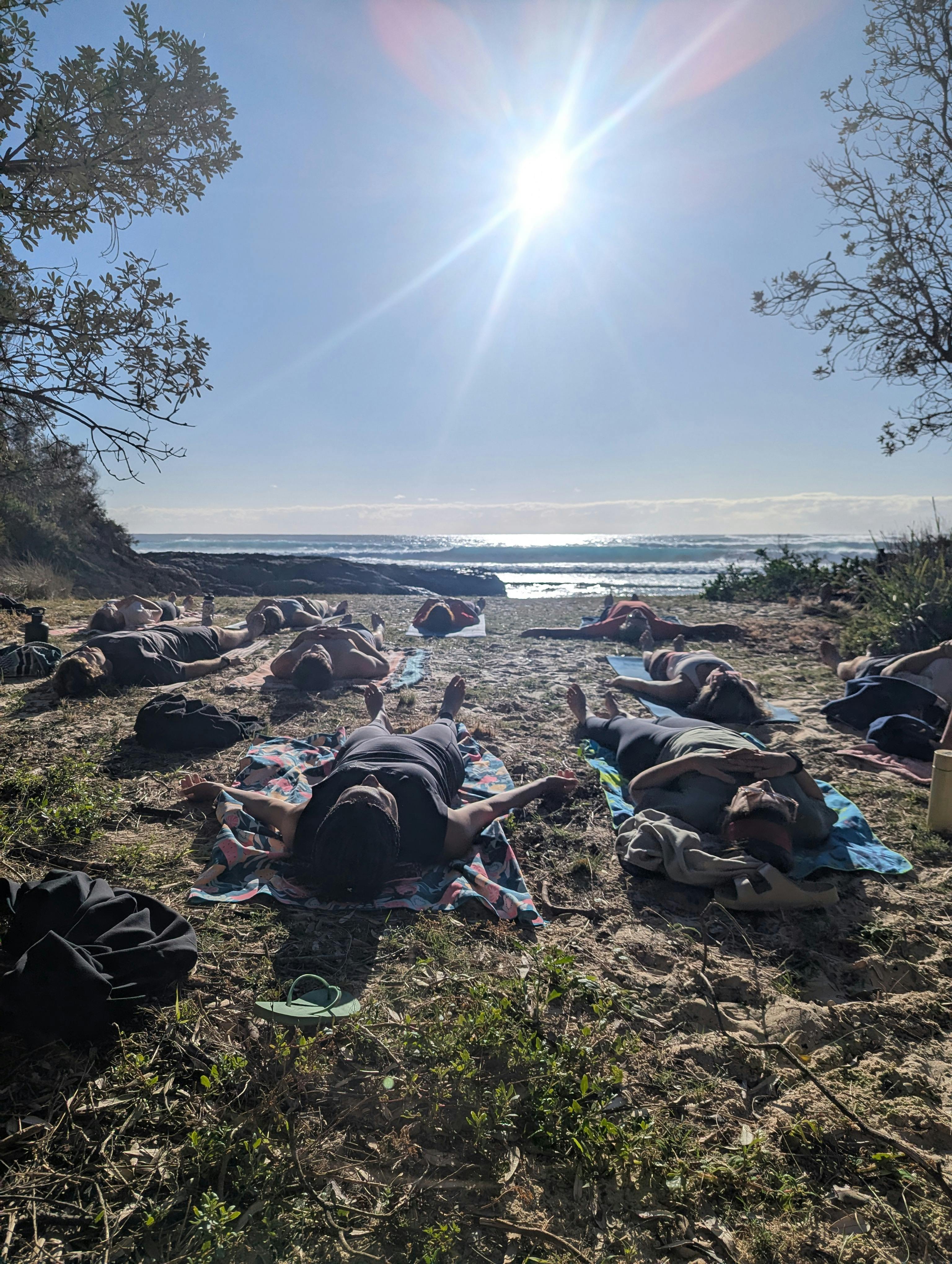 Relaxing Savasana after a barefoot beach yoga session, Australia.
