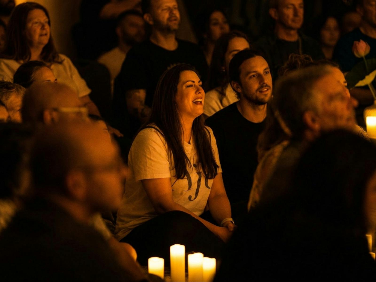 Woman seated smiling, singing
