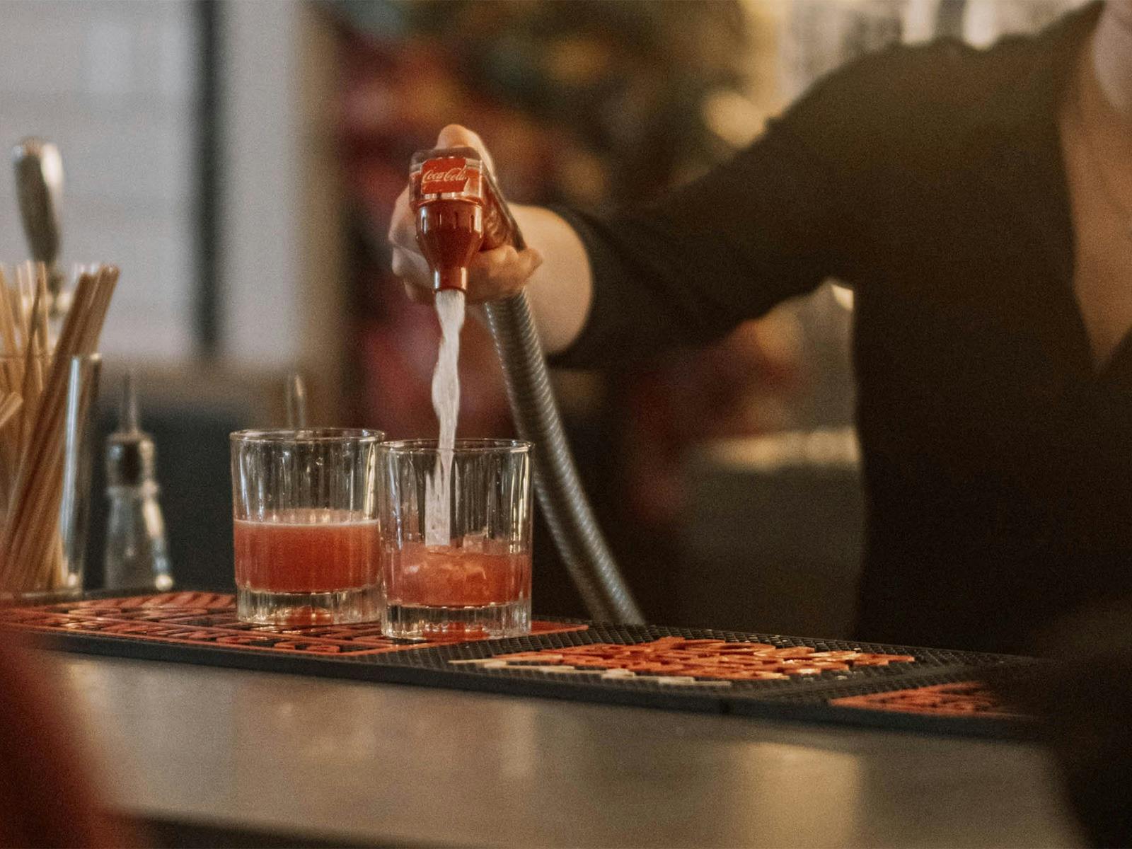 Bar person mixing drinks in back bar