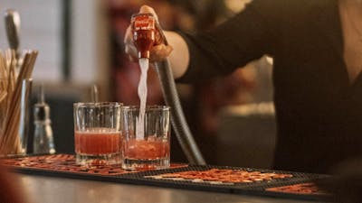 Bar person mixing drinks in back bar