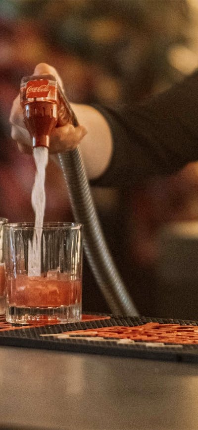Bar person mixing drinks in back bar