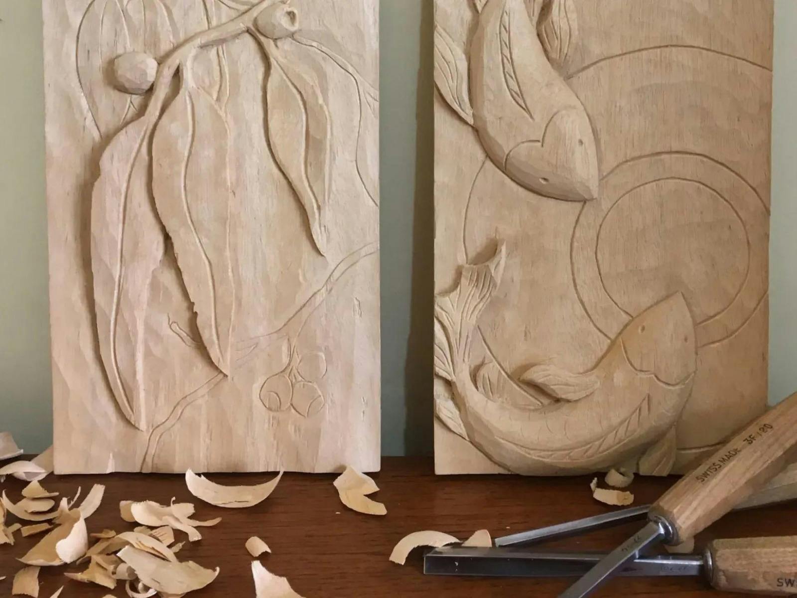 Two hand carved wood panels. One with gum leaf design, the other with koi fish
