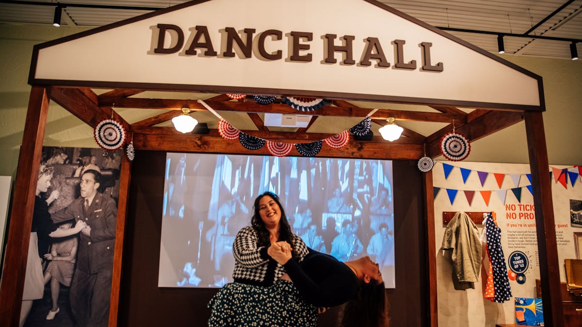 Two ladies dancing inside a small dance hall display inside the interactive exhibit