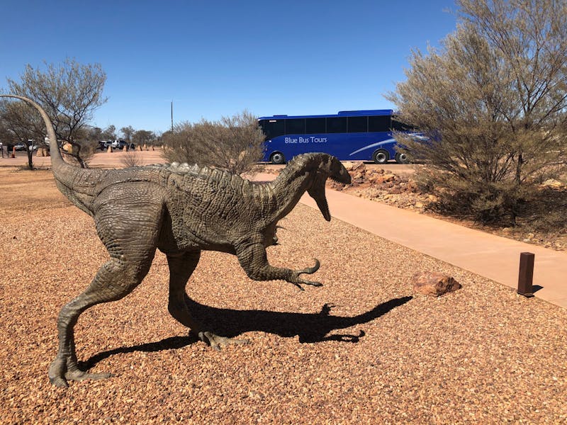 Bus behind dinosaur statue