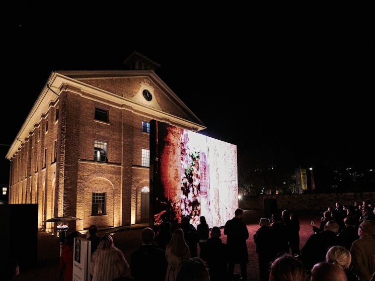 A large video installation in in front of the Hyde Park Barracks