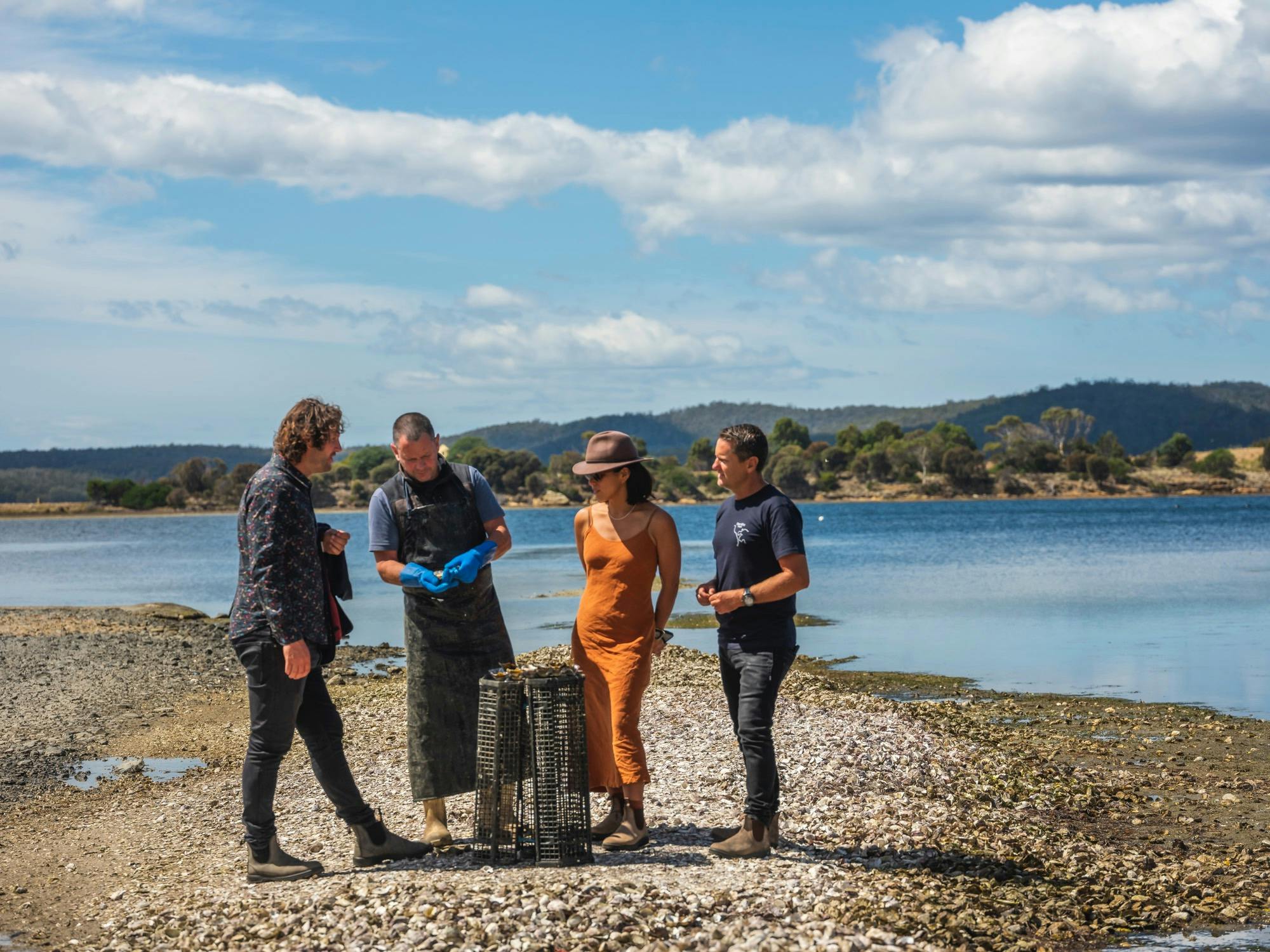 oyster farmer shucking fresh oysters for tour guest in dunalley