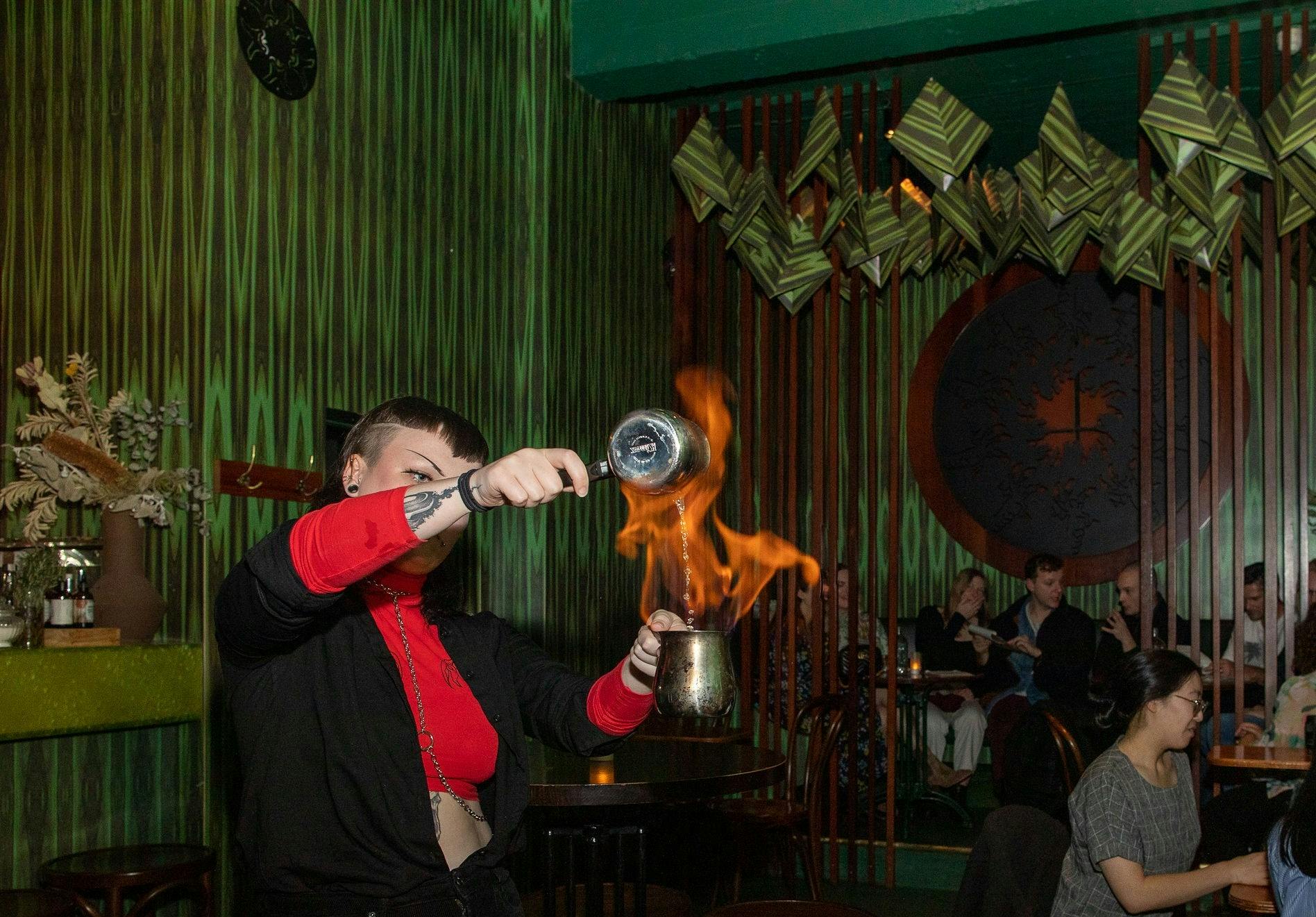 Bar staff creating a cocktail using fire