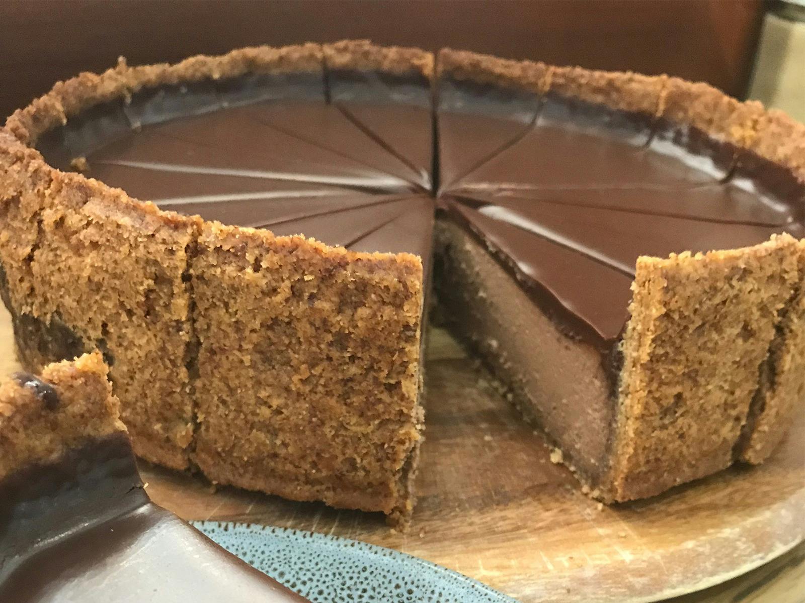 delicious chocolate cheesecake with gluten-free crust, topped with rich ganache
