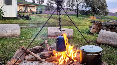 cooking over the campfire, serenity cabin in the background