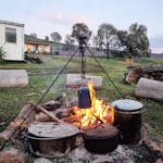 cooking over the campfire, serenity cabin in the background