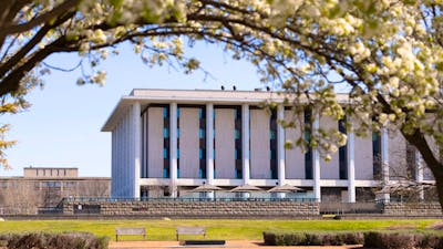 The National Library of Australia building with park benches and trees in the image.