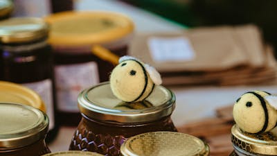 Bees on top of honey jars at Haig Park Vil