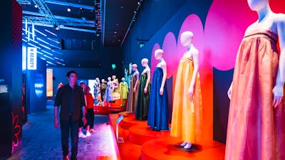 Korean fashion being displayed on mannequins with a young man walking alongside the display.