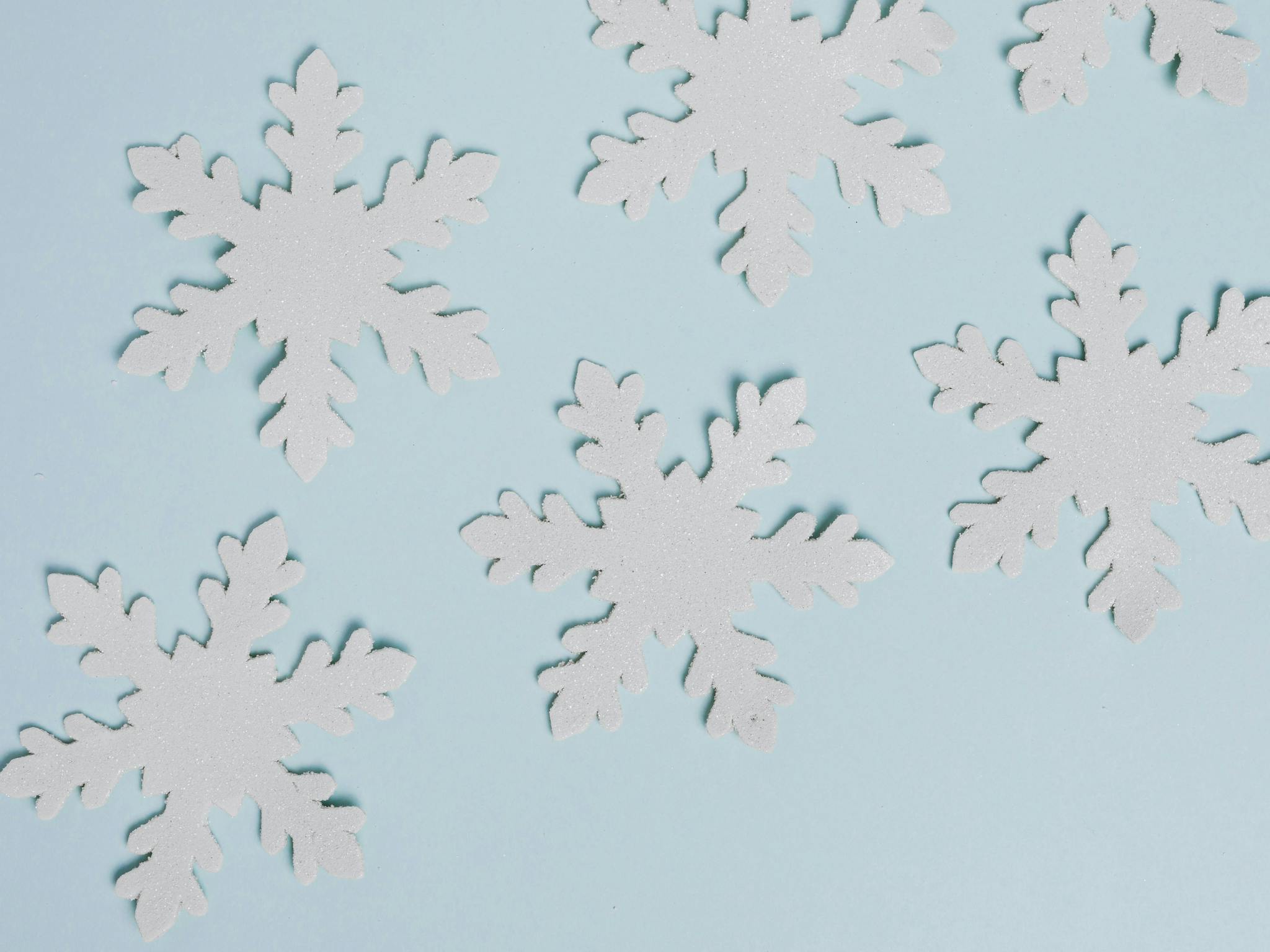 Handmade paper snowflakes on blue background