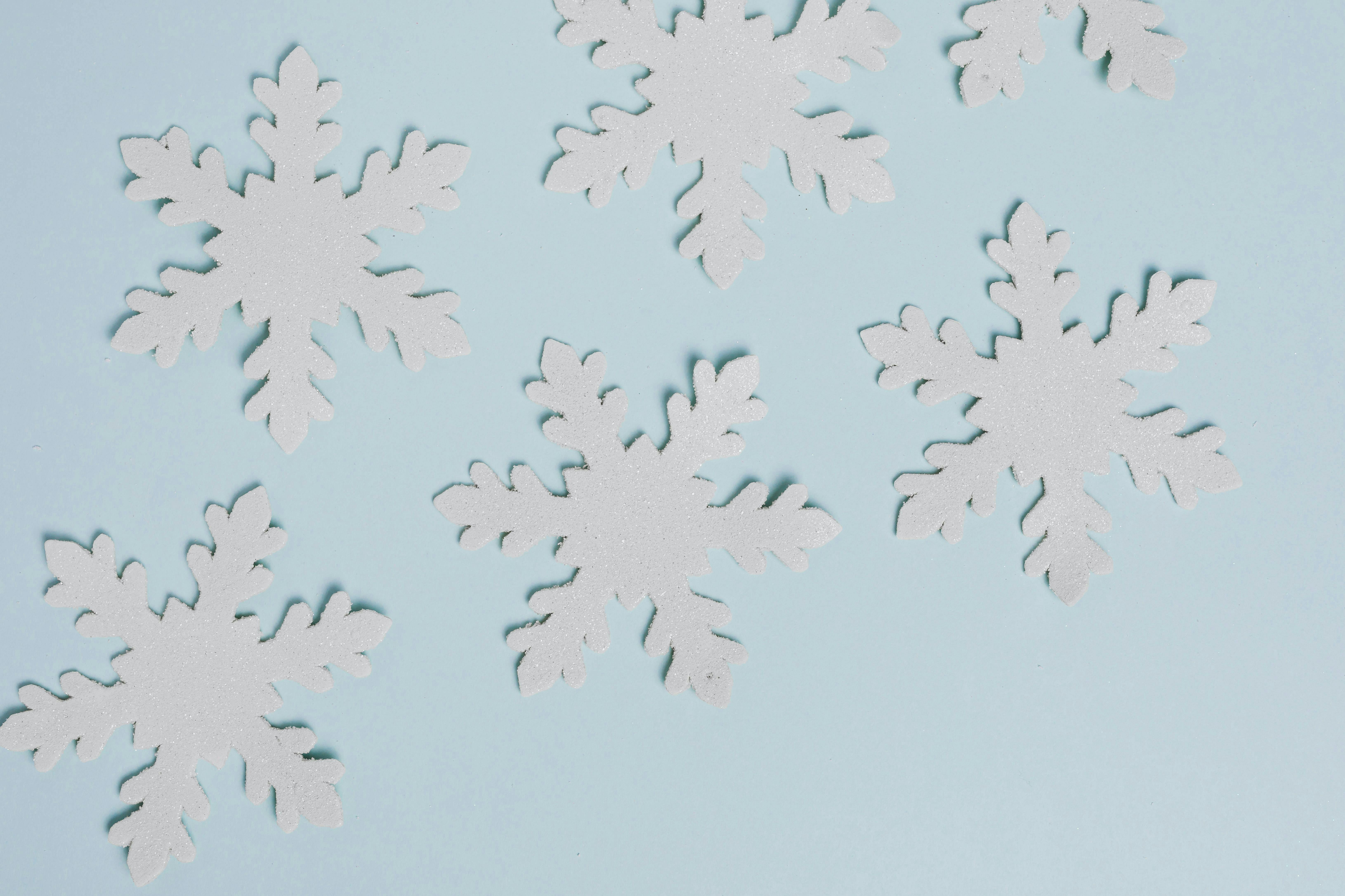 Handmade paper snowflakes on blue background