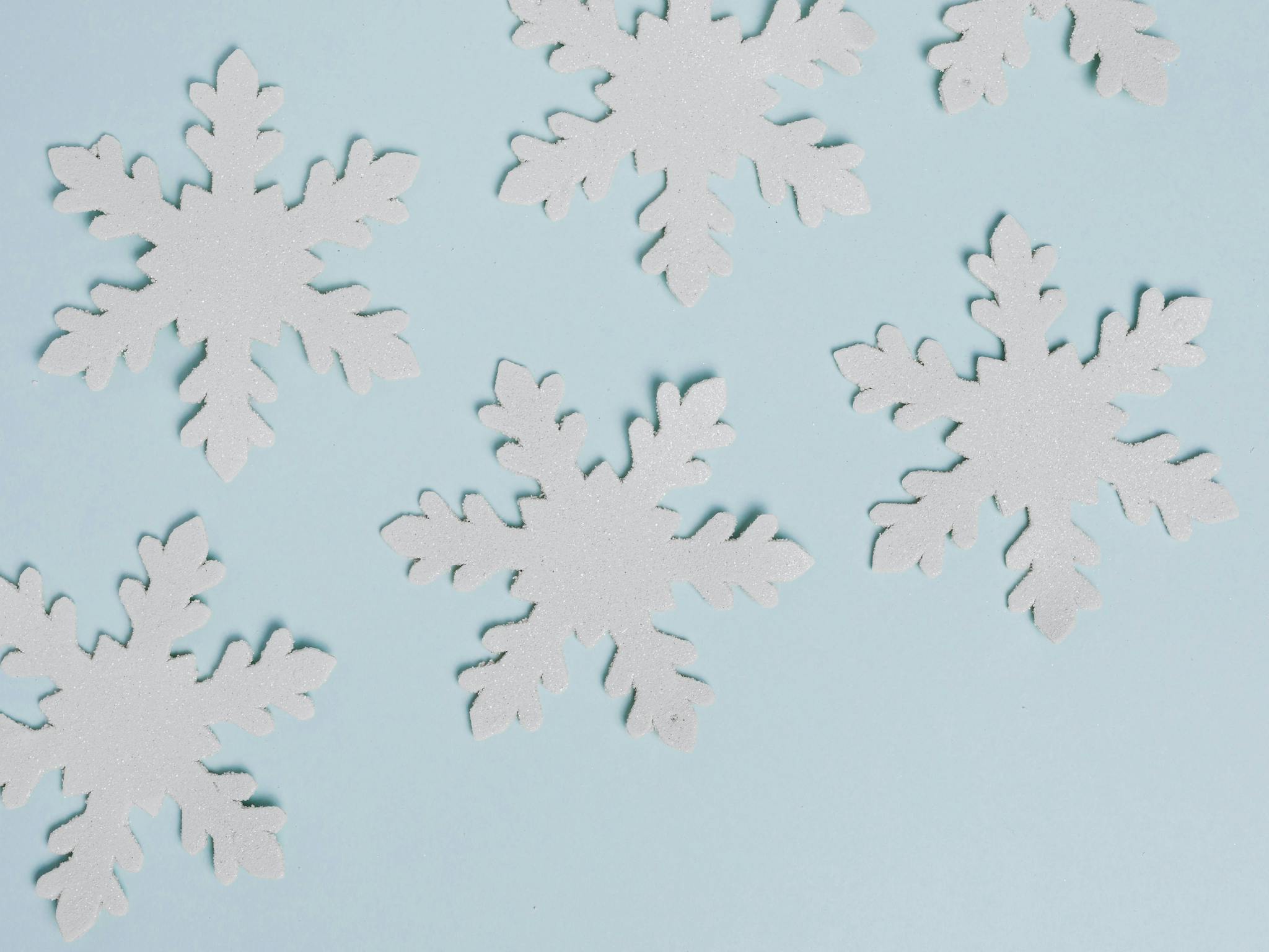 Handmade paper snowflakes on blue background