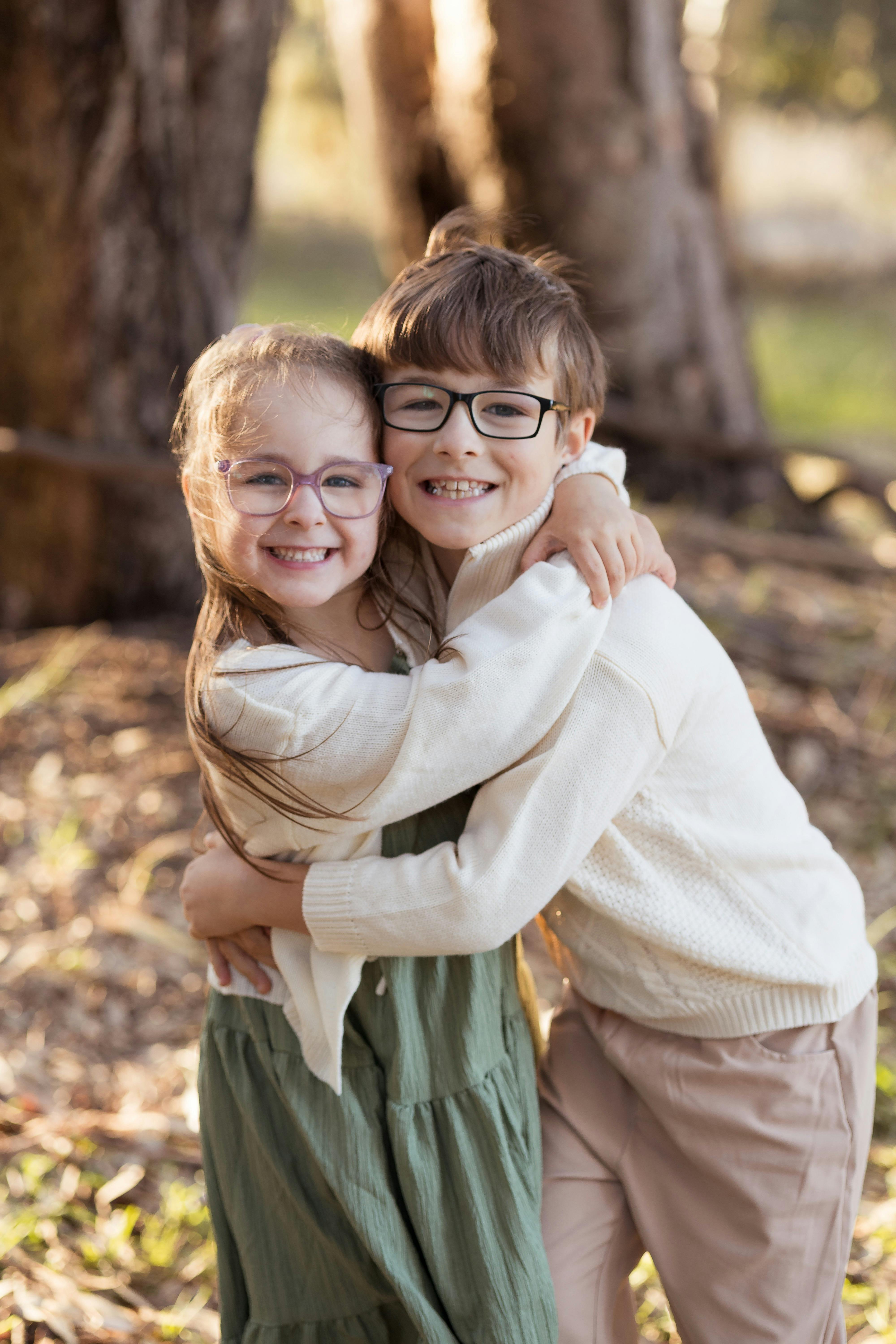 Siblings sharing a hug in a scenic outdoor area