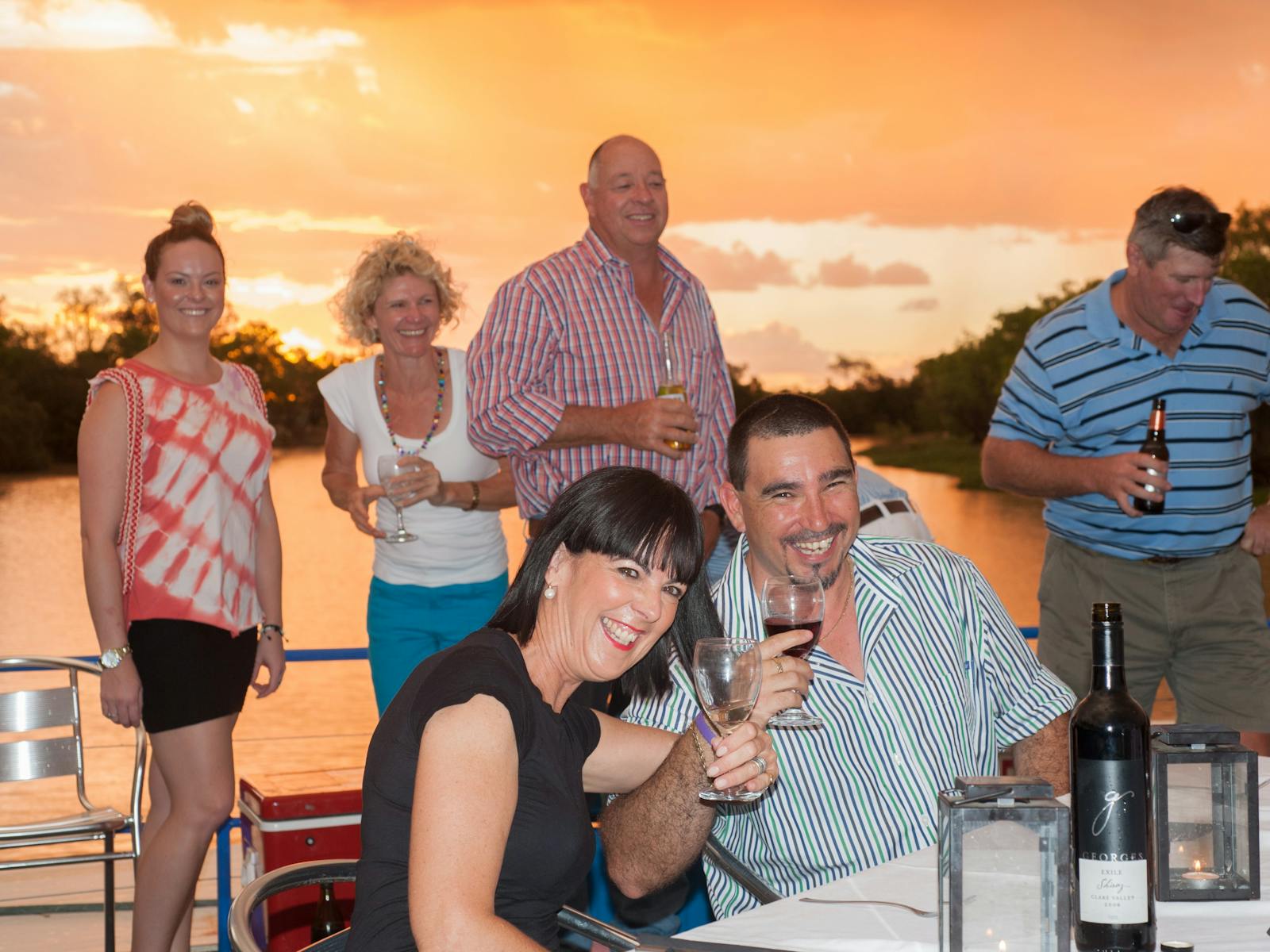 Guests group photo enjoying a beverage on Smithy's Sunset Cruise