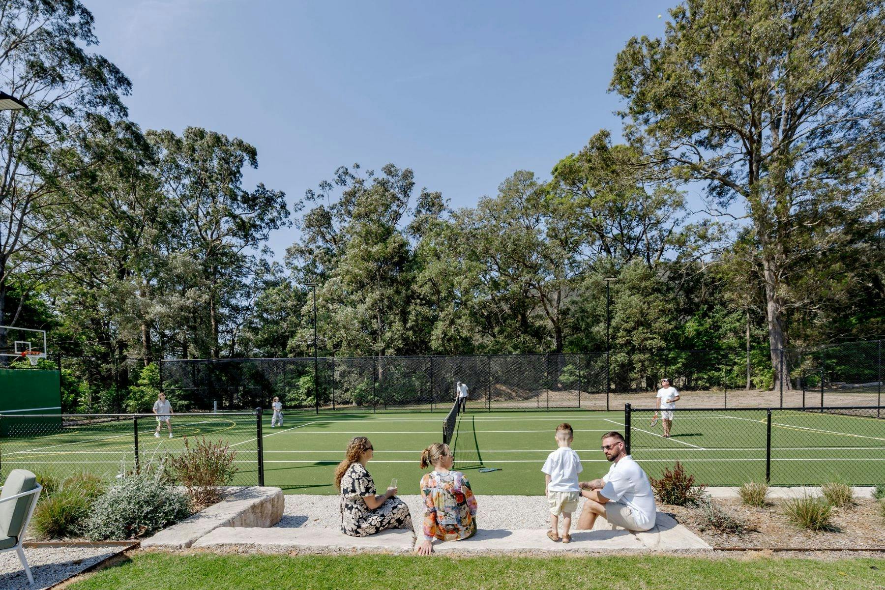 Image of guests enjoying watching kids play on basketball court and tennis court
