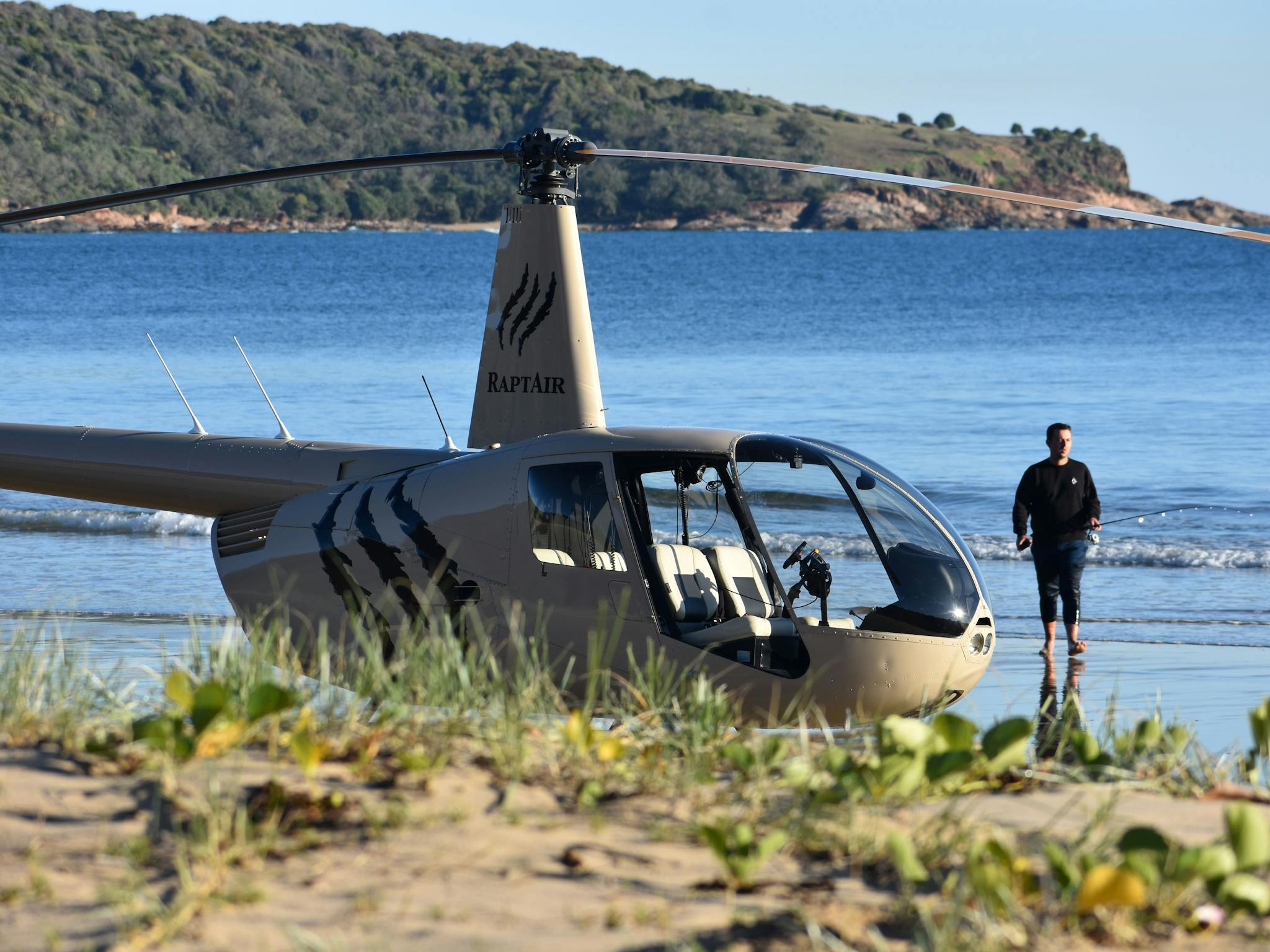 person standing behind the helicopter wading in clear waters person standing behind the helicopter wading in clear waters