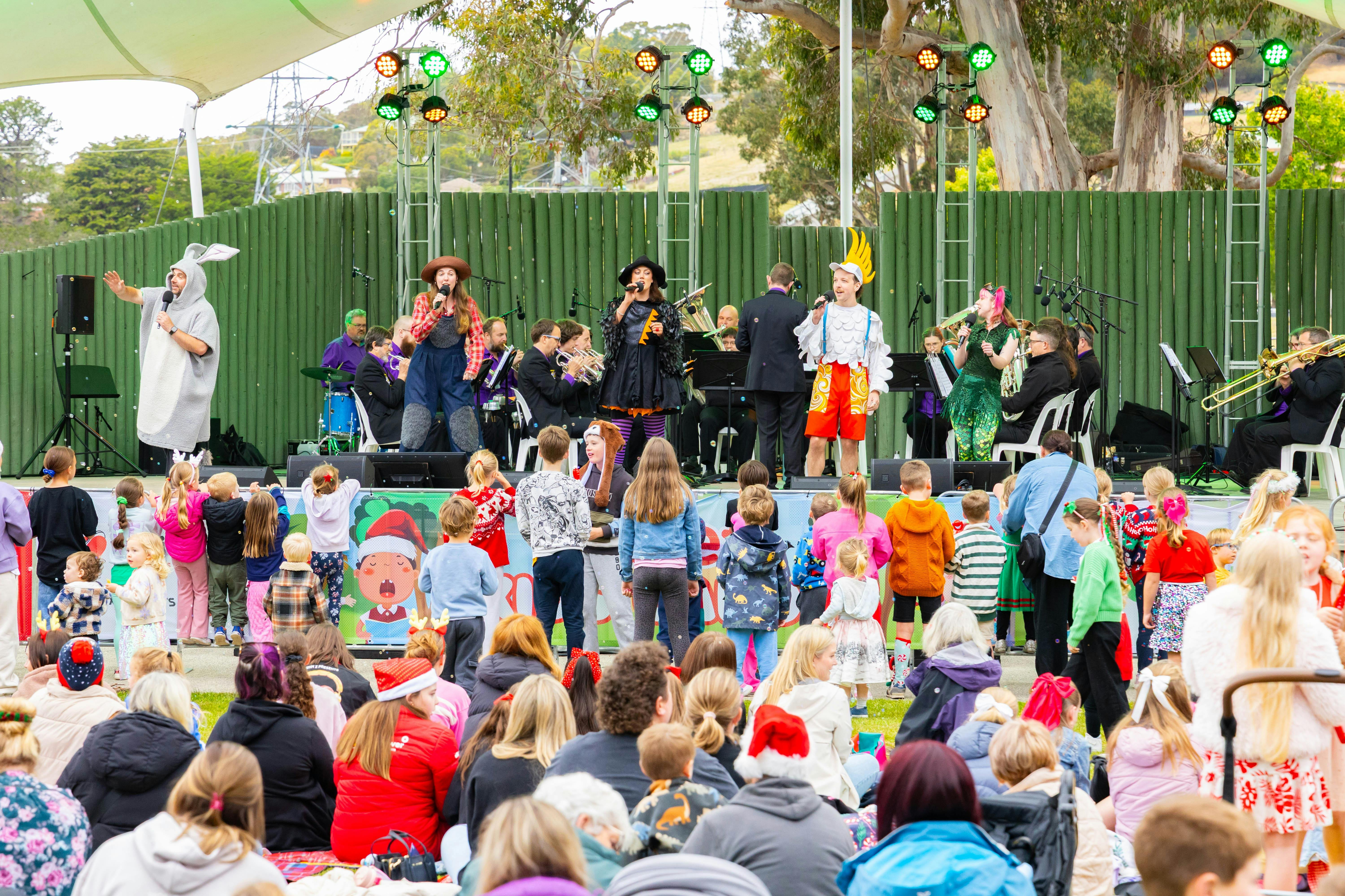 Performers on stage in crazy costumes singing Christmas Carols