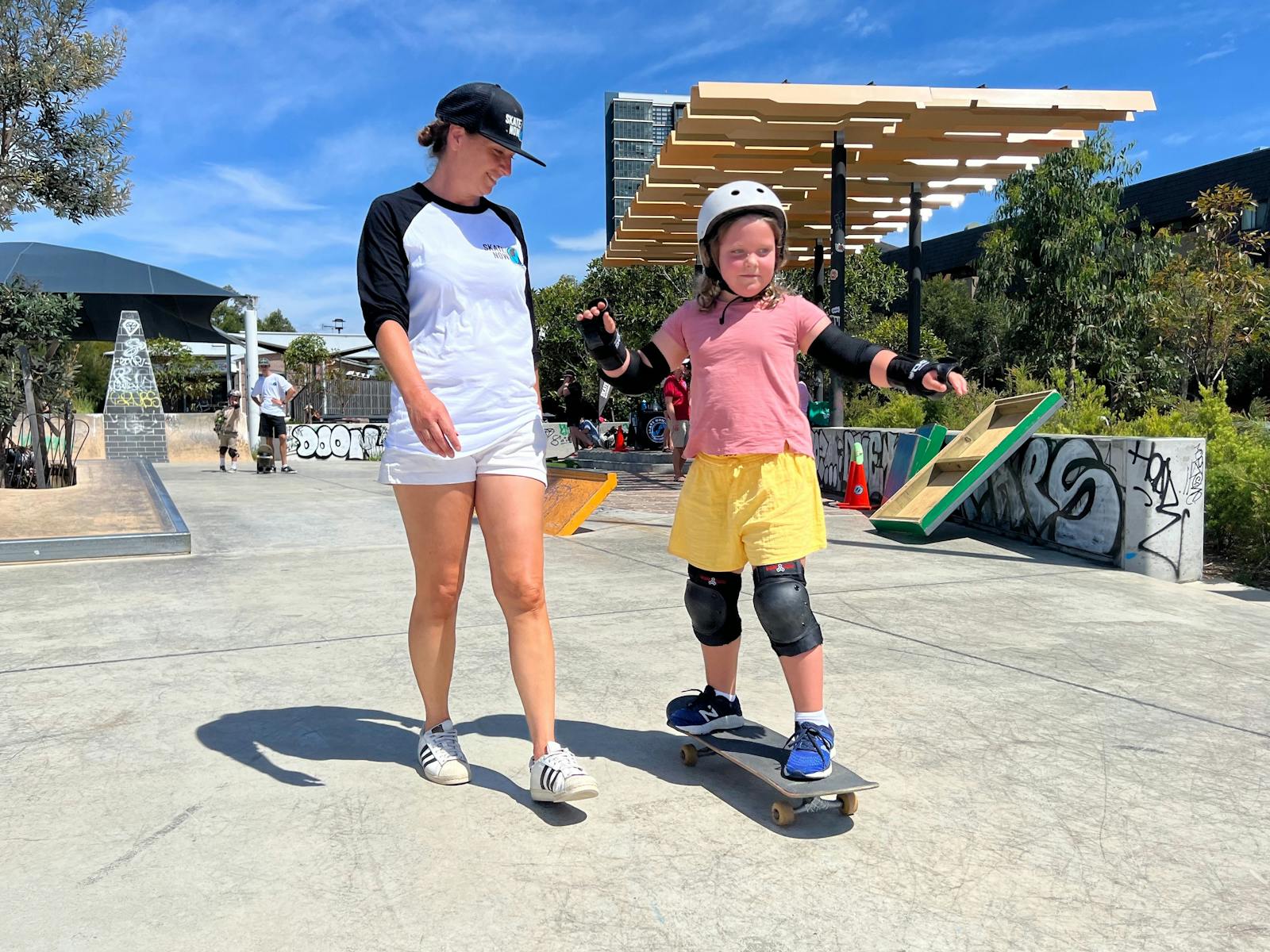 一名初学者在滑冰教练的指导下学习如何推。