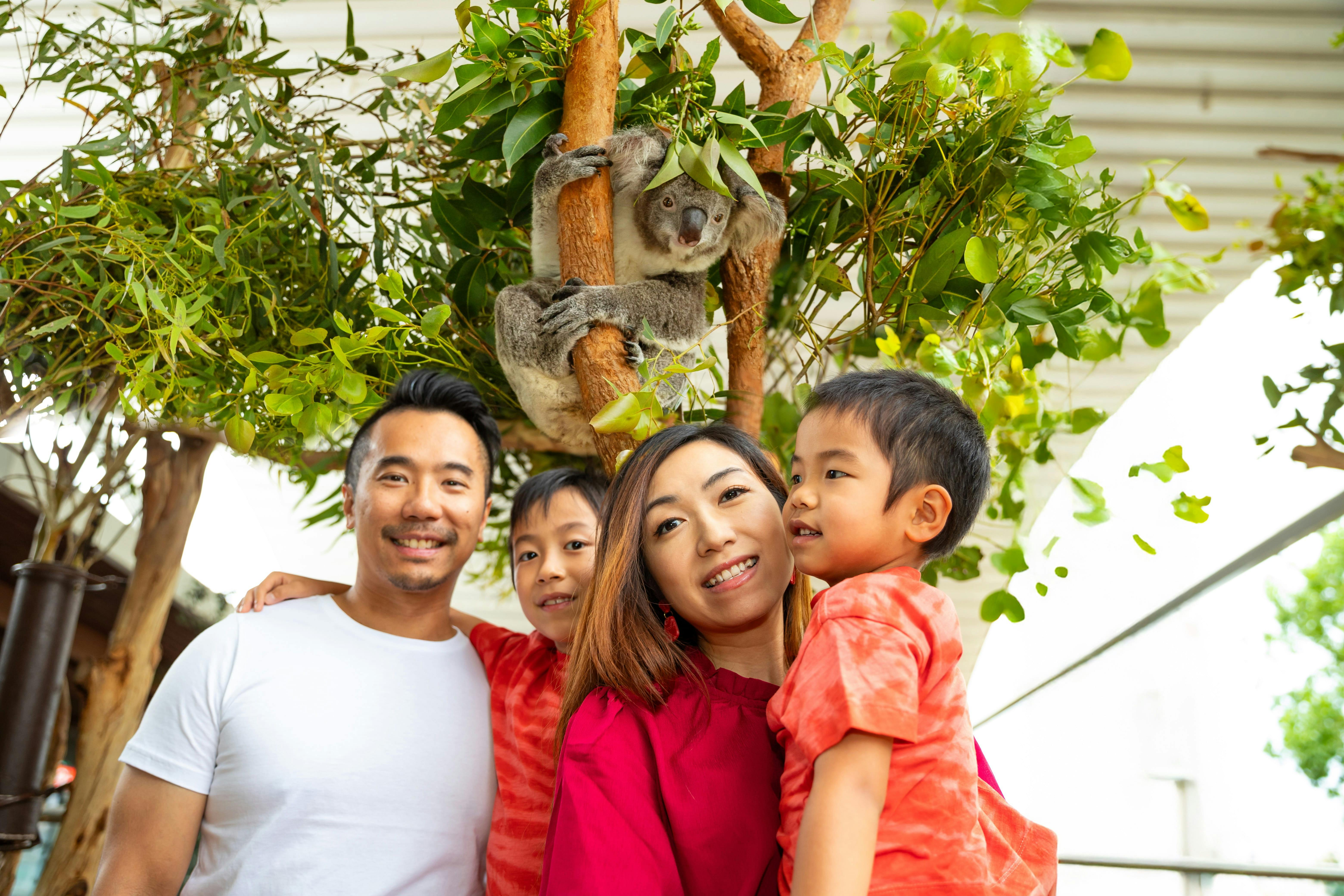 Family in zoo posing with koala