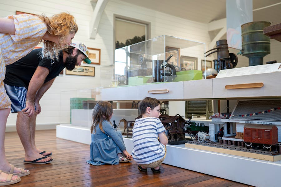 Two children looking at models of buildings with their parents looking on.