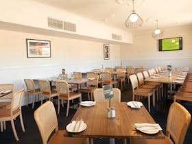 Spacious and well-lit dining area at Risdon Hotel with set tables.