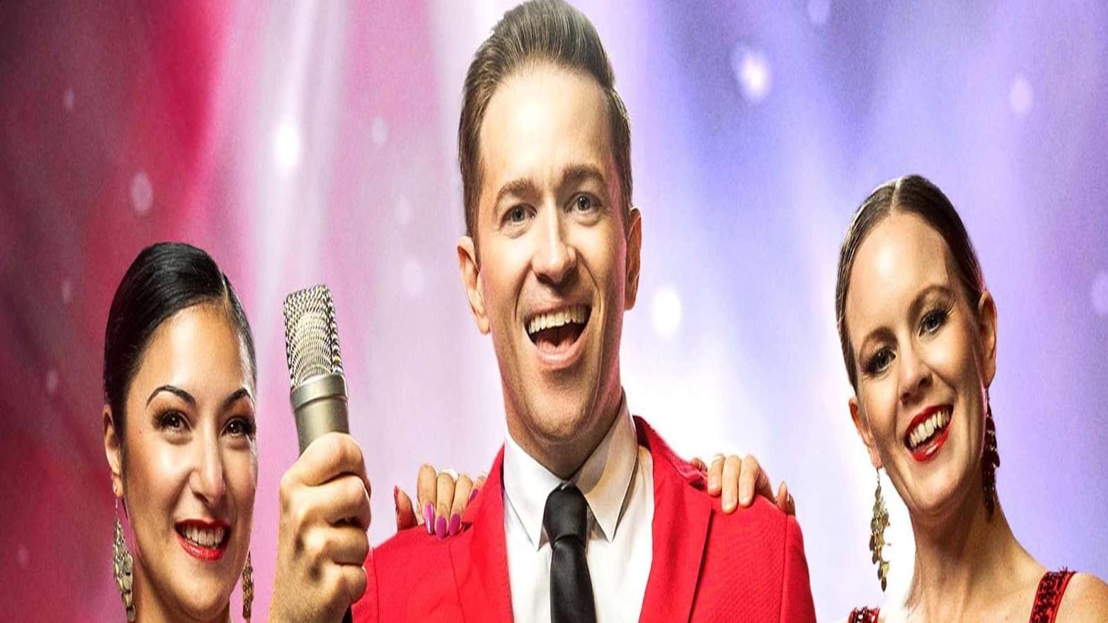 Three performers dressed in red formal outfits, looking at the camera smiling. Three performers dressed in red formal outfits, looking at the camera smiling.