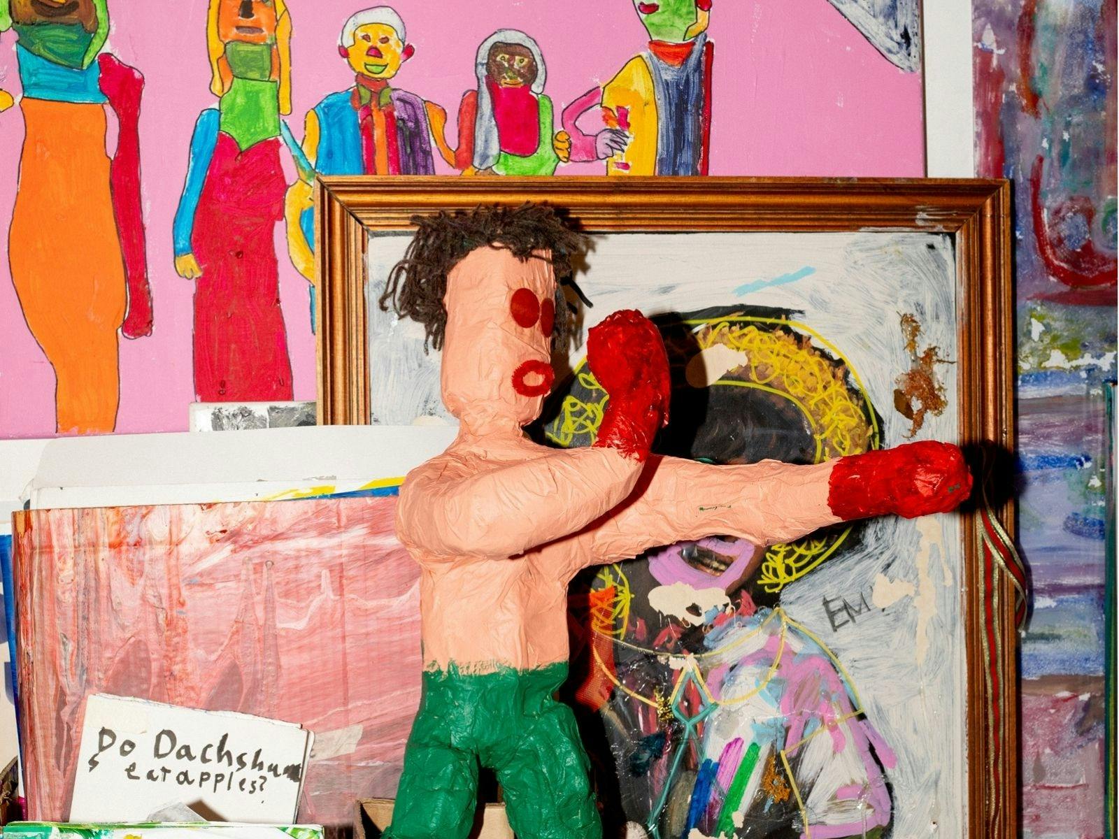Photograph of brightly coloured, eclectic artworks in a studio.