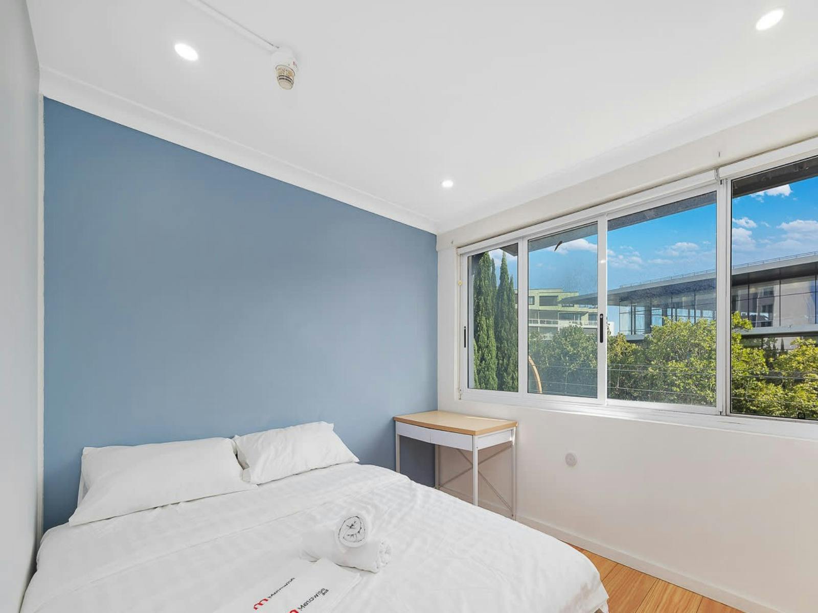 Bright and airy bedroom featuring a comfortable queen-size bed, large windows, and a peaceful ambian