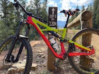 A red and yellow bike leans against a post at the top of the mountain bike trail.