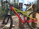 A red and yellow bike leans against a post at the top of the mountain bike trail.