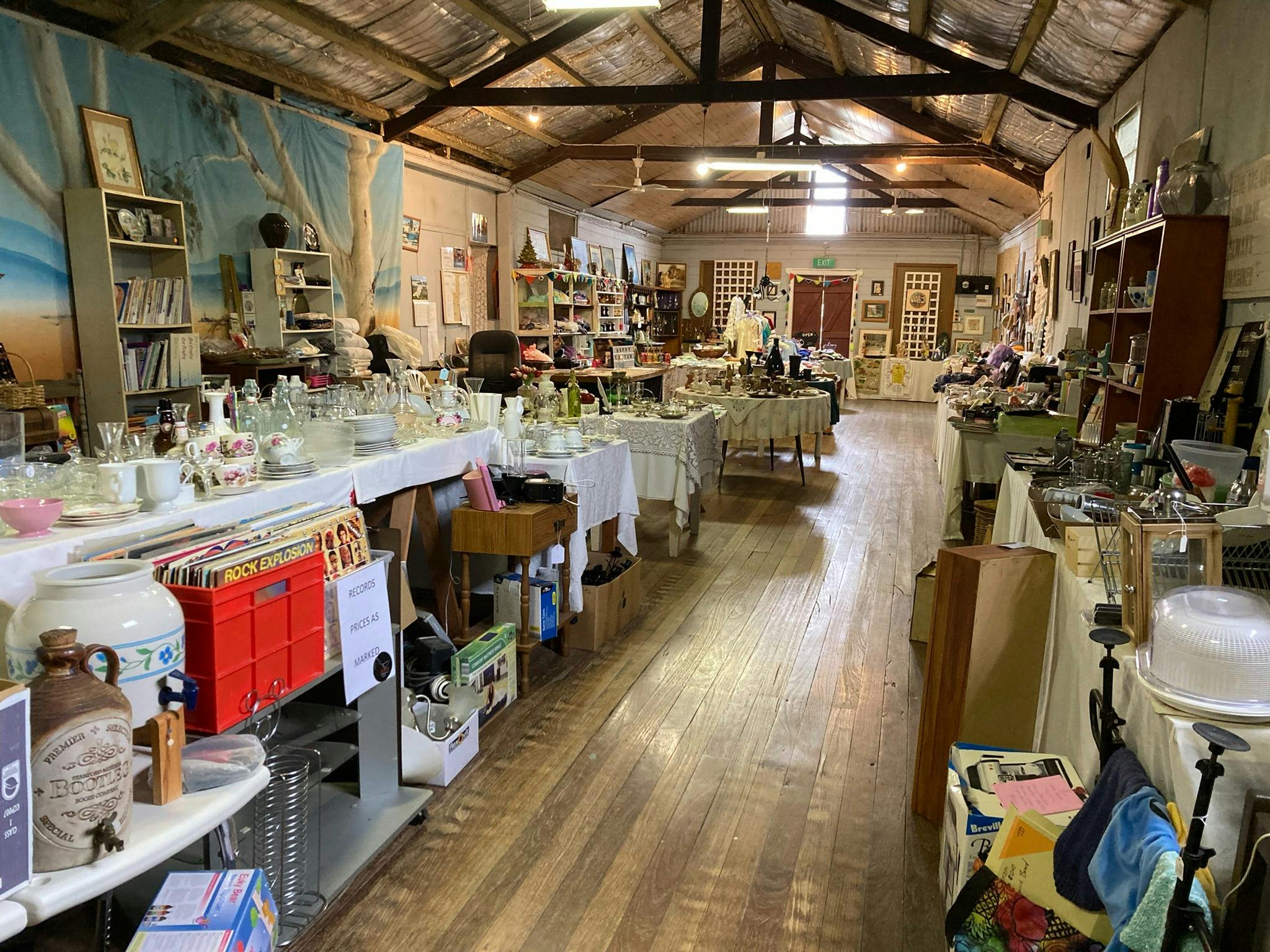 Interior of a hall showing open rafters above and tables running longways with homewares and gifts