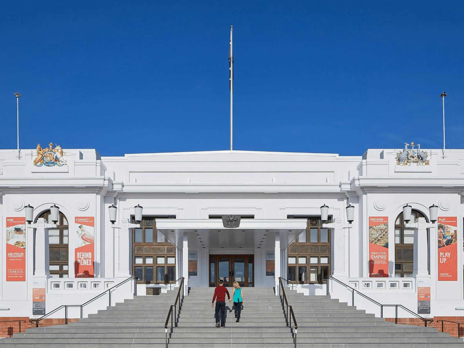 Two people walk up the steps of Old Parliament House