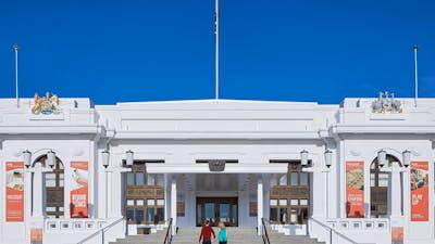 Two people walk up the steps of Old Parliament House