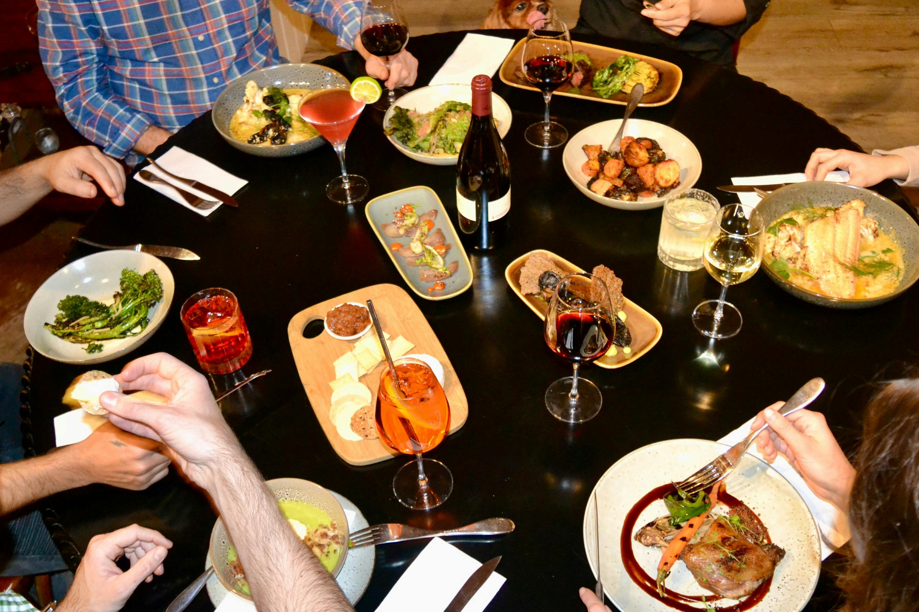 Chef Sergio Soto plating house‑made bread and vibrant starters in Feathertop’s open kitchen, fresh i