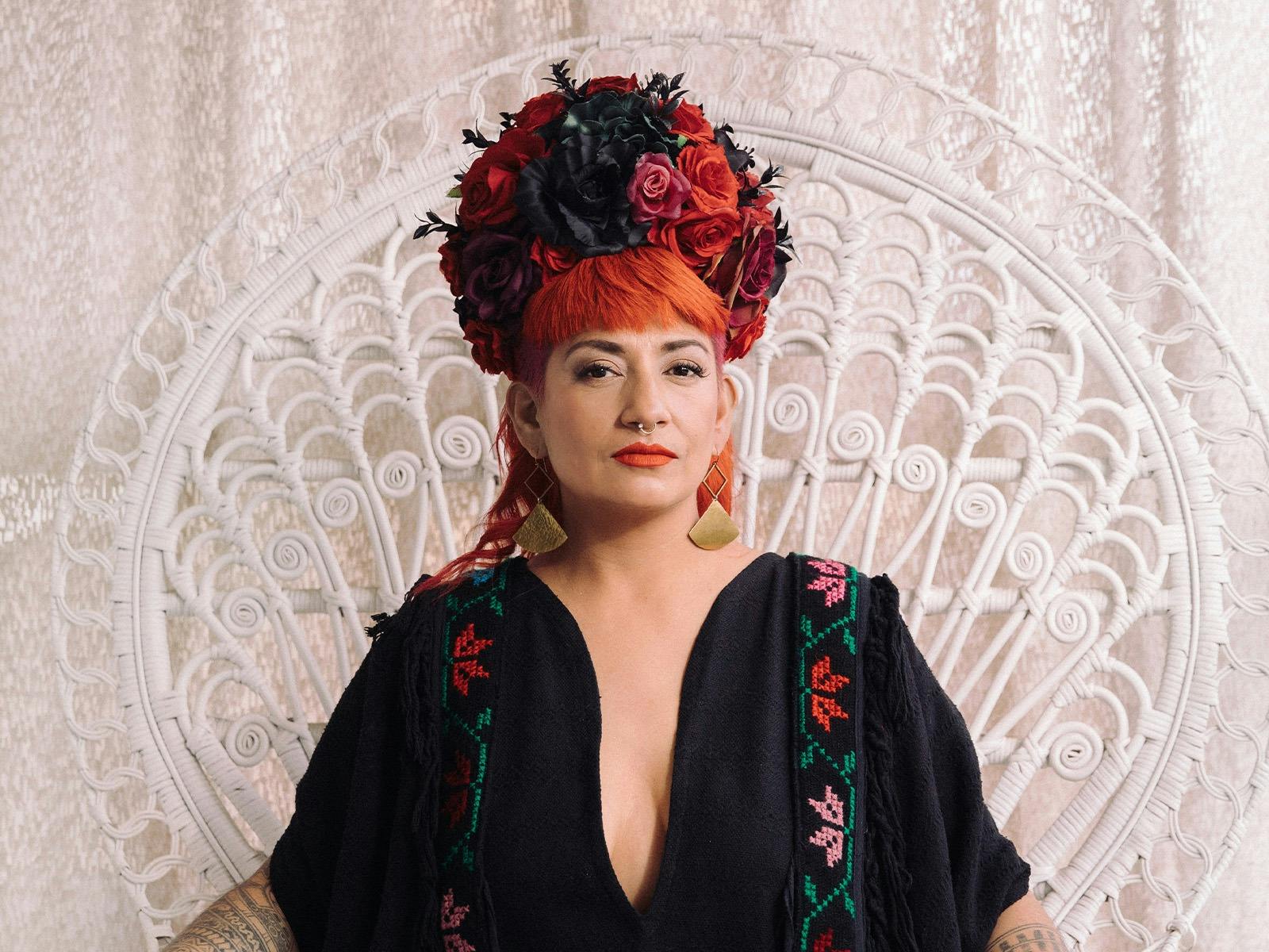 Mambe sitting on large white chair with flower hat on
